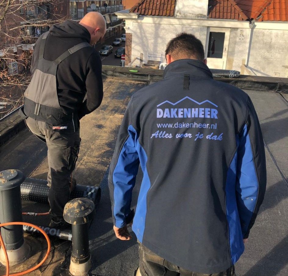 De dakdekkers van daken heer aan het werk op een bitumen dak.